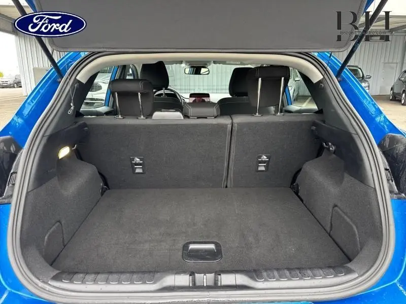 Coffre ouvert vu de l'arrière d'un Ford Puma 2023 bleu Fashion Island, intérieur tissu noir Kasbah, banquette arrière relevée.