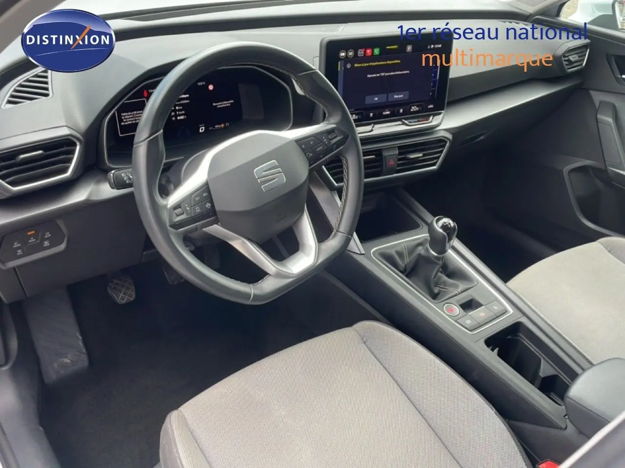 Vue intérieure côté conducteur du SEAT LEON 2.0 TDI 115CH STYLE XL 2025, volant cuir, tableau de bord numérique et levier manuel.