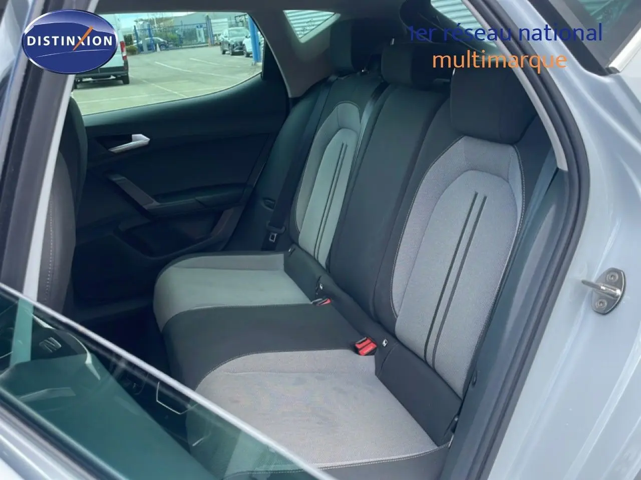 Vue intérieure côté droit montrant la banquette arrière gris clair et noir du SEAT LEON blanc neige métal 2025.