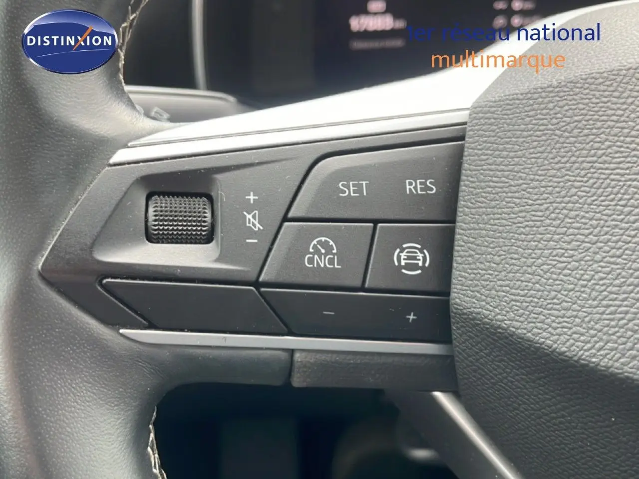 Gros plan sur les commandes au volant à gauche du SEAT LEON blanc neige métal, version 2.0 TDI 115CH STYLE XL 2025.