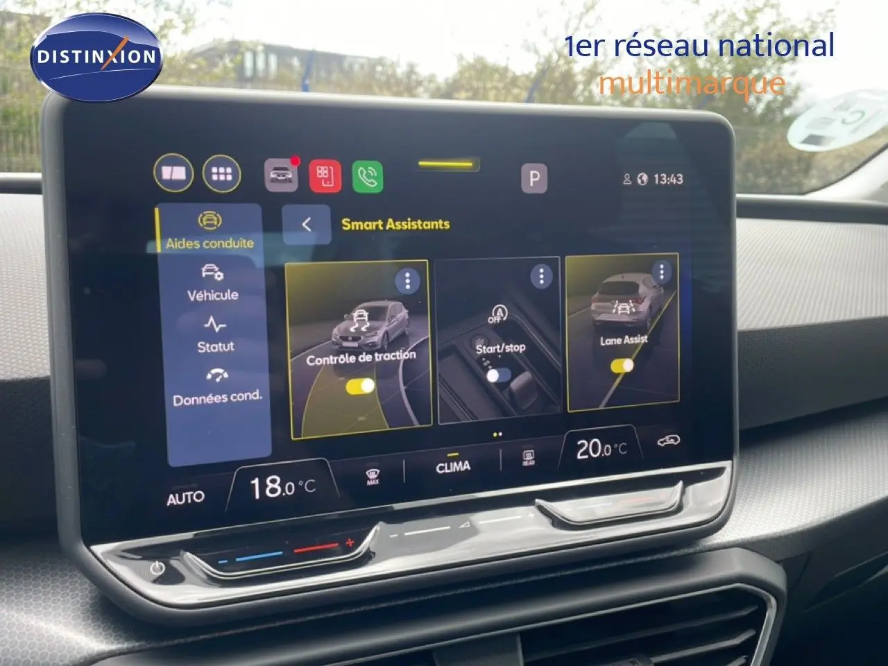 Vue intérieure centrée sur l'écran tactile du tableau de bord du SEAT LEON blanc neige, affichant les assistants de conduite.