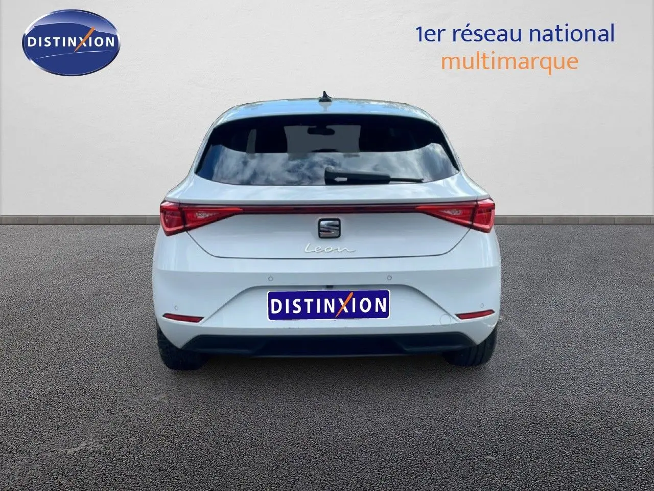 Vue arrière d'une SEAT Leon 2025 blanche neige métal, avec feux arrière LED et vitre arrière teintée.