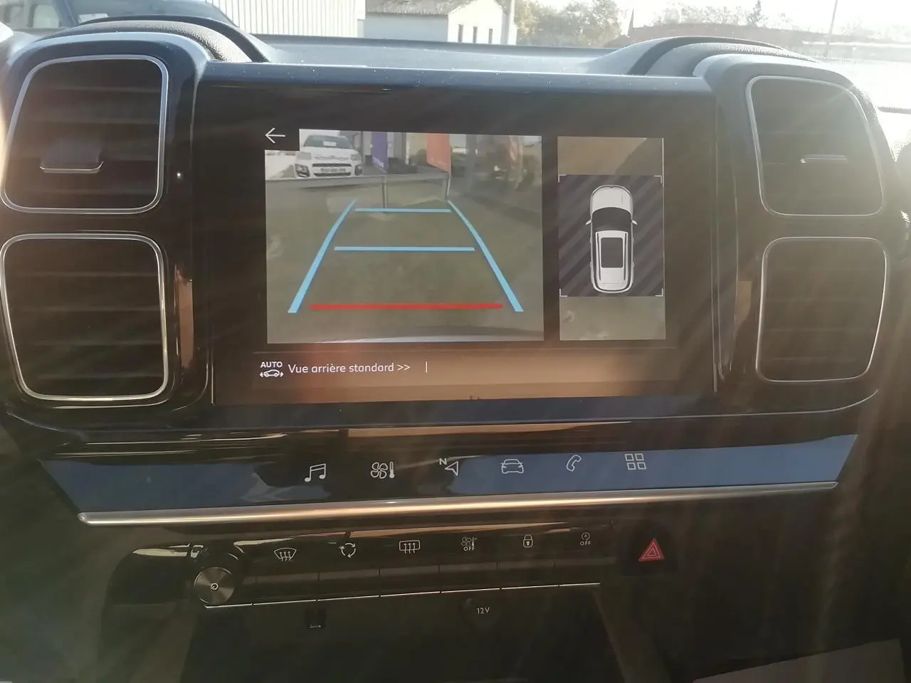 Vue intérieure du tableau de bord du Citroën C5 Aircross gris, écran tactile affichant la caméra de recul et l'aide au stationnement.
