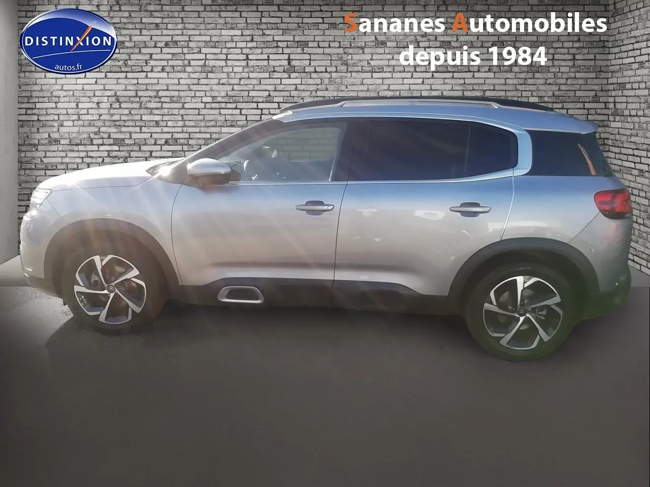 Profil droit d’un Citroën C5 Aircross gris métallisé 2019 avec jantes alliage et barres de toit bi-ton.