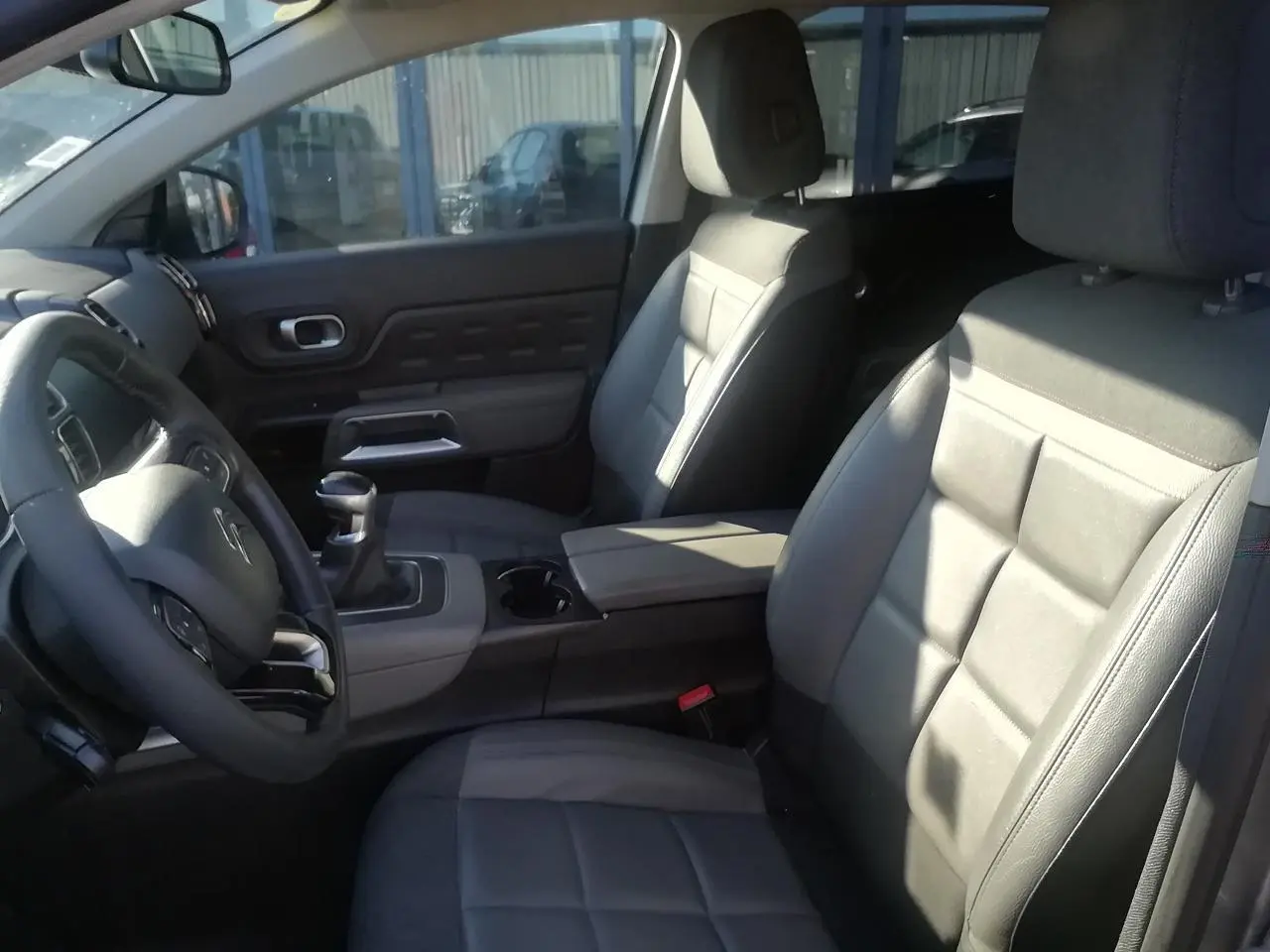 Vue intérieure côté conducteur du Citroën C5 Aircross gris, montrant sièges Advanced Comfort et levier de vitesses manuel.