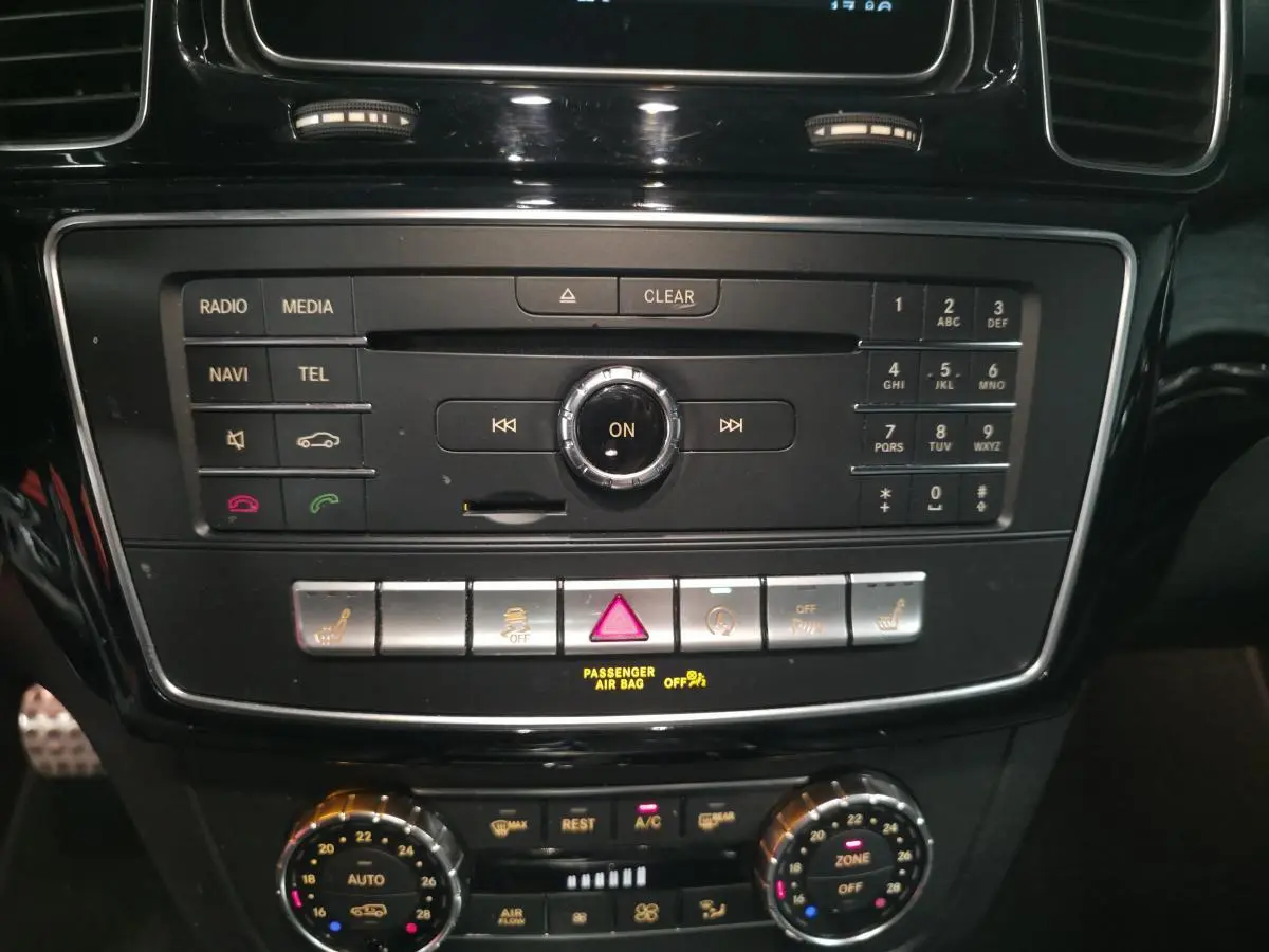 Gros plan sur la console centrale noire du Mercedes GLE 350 d AMG Line avec commandes multimédia et climatisation.