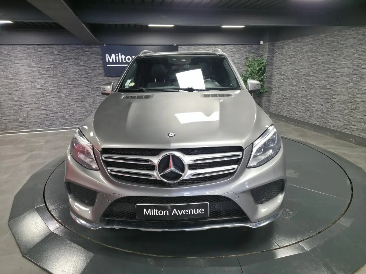 Vue avant d’un Mercedes GLE 350 d gris clair AMG Line, avec calandre chromée et logo étoile central.