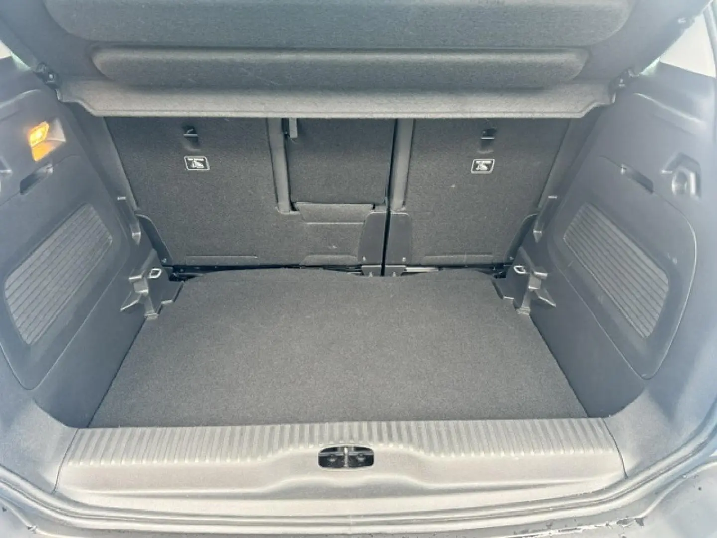 Coffre ouvert vu de face du Citroën C3 Aircross 2024, intérieur noir avec banquette arrière rabattable.