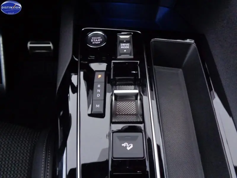 Gros plan sur la console centrale brillante du Peugeot 3008 2023, avec sélecteur de boîte auto et bouton start/stop.