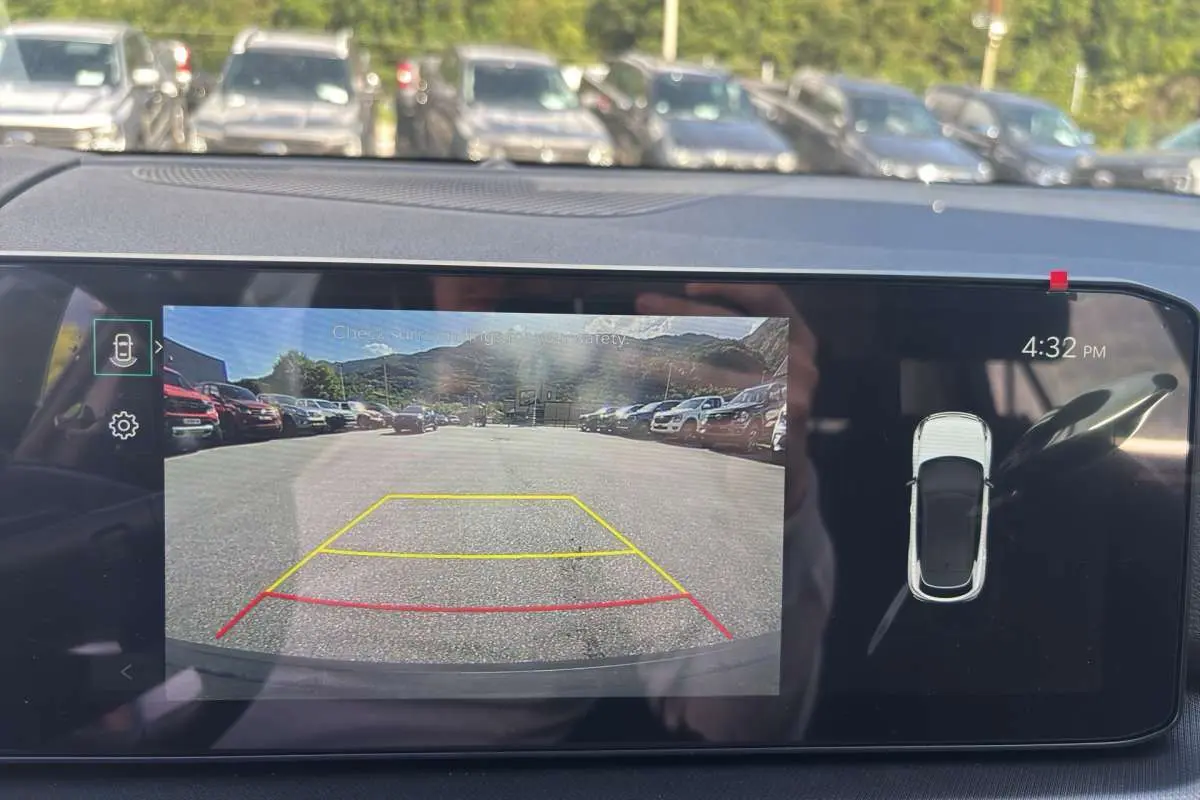 Écran de caméra de recul du Kia Sportage gris céramique montrant l'arrière avec lignes de guidage colorées.