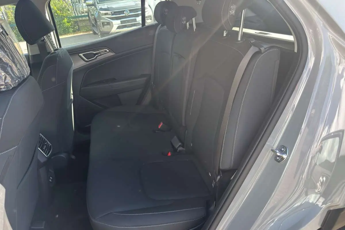 Vue intérieure côté droit sur la banquette arrière noire du Kia Sportage 2026 gris céramique avec ceinture de sécurité visible.
