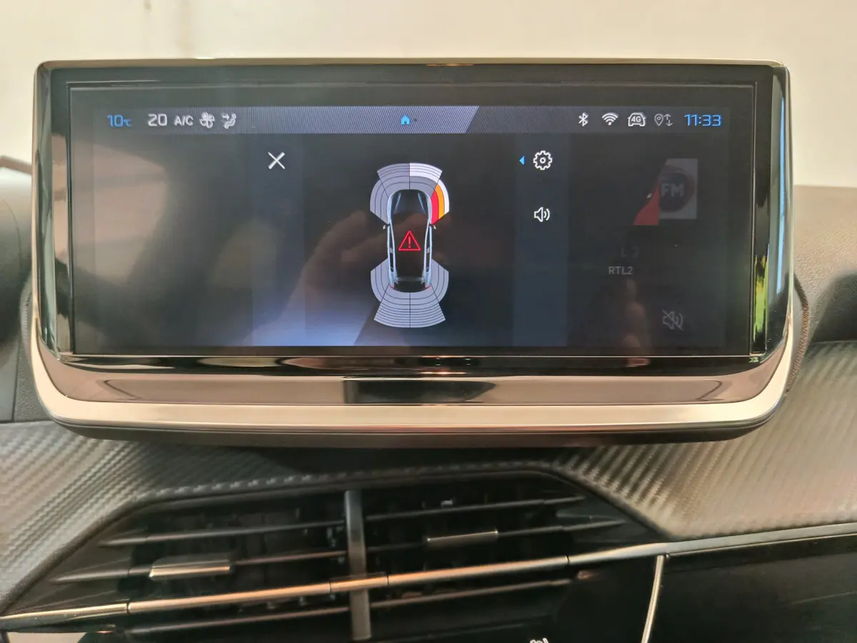 Écran tactile central de la Peugeot 208 PureTech 100 S&S Allure 2025 affichant l'alerte de proximité en vue intérieure.