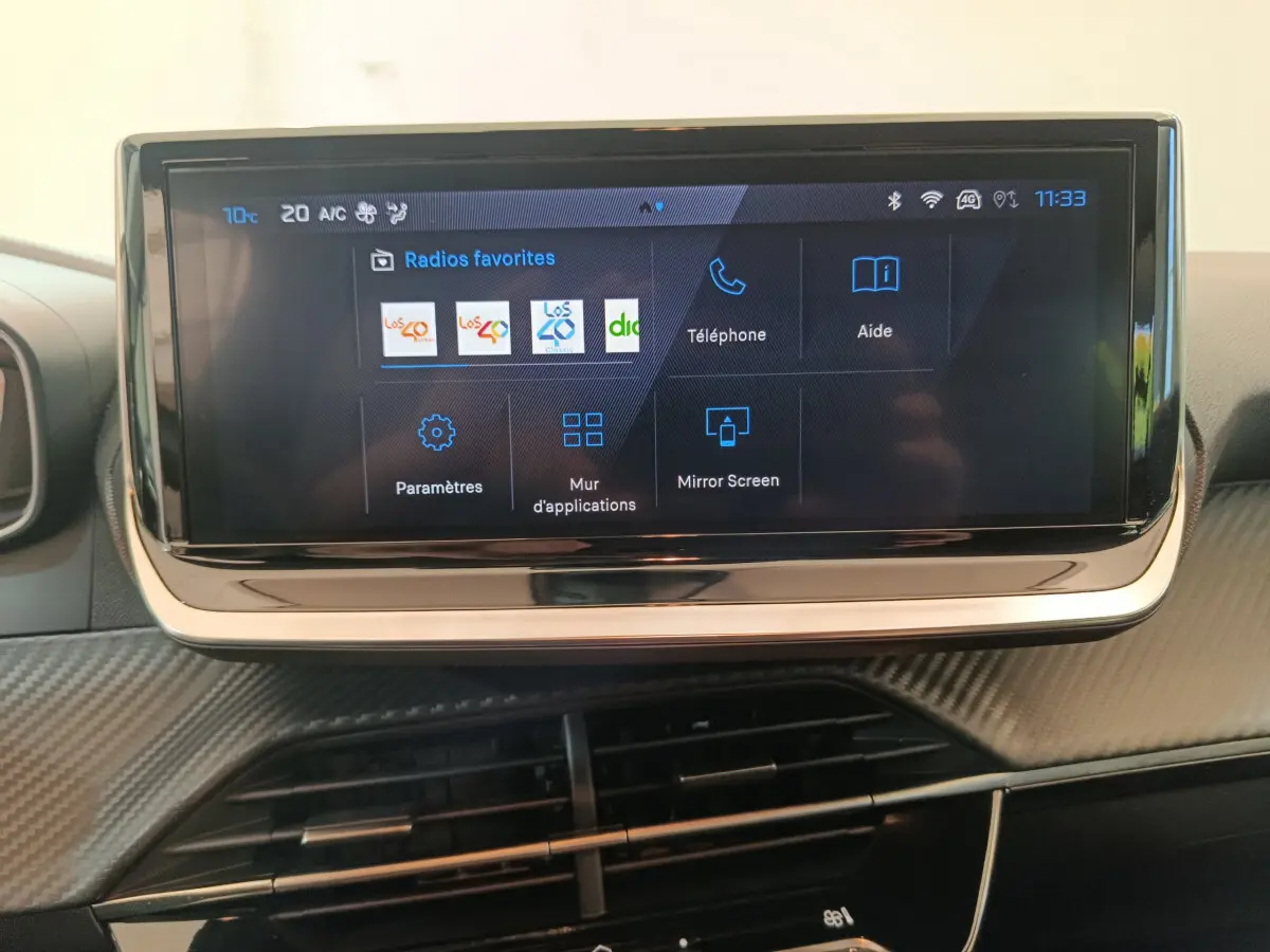 Écran tactile central de 10 pouces affichant les radios favorites dans l'habitacle du Peugeot 208 gris foncé.