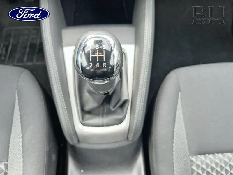 Le levier de vitesses manuel noir et chrome vu de dessus entre les sièges gris d'une Nissan Micra 2022