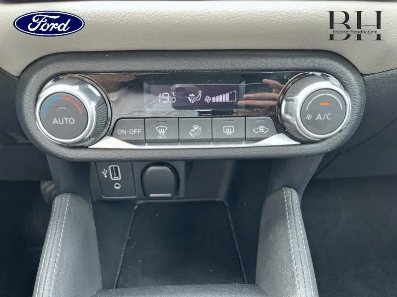 Panneau de commande de climatisation avec réglages numériques et boutons, intérieur noir d'une Nissan Micra gris acier.