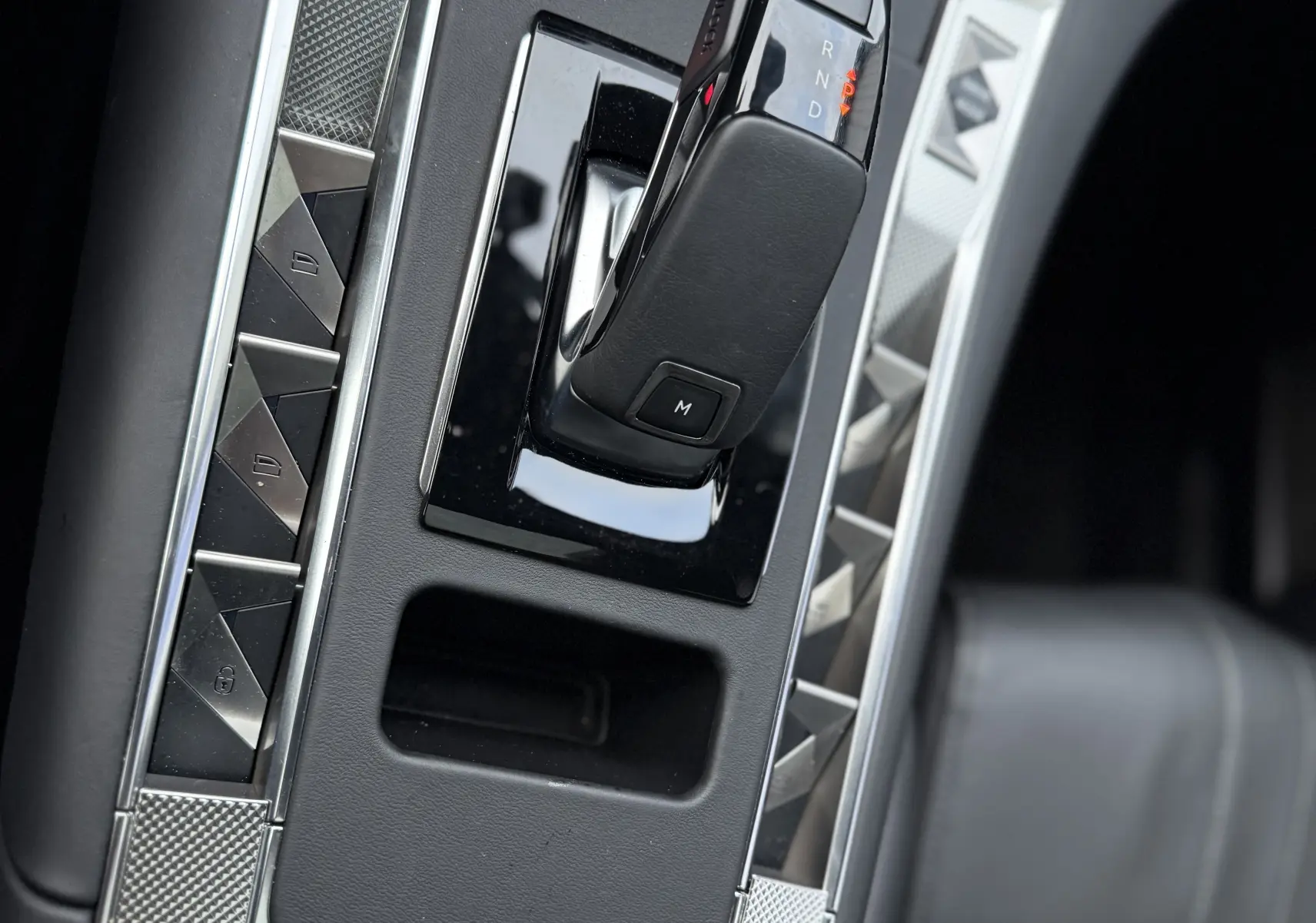 Gros plan sur la console centrale du DS7 2025, boîte auto noire avec finitions argentées et cuir noir visible.