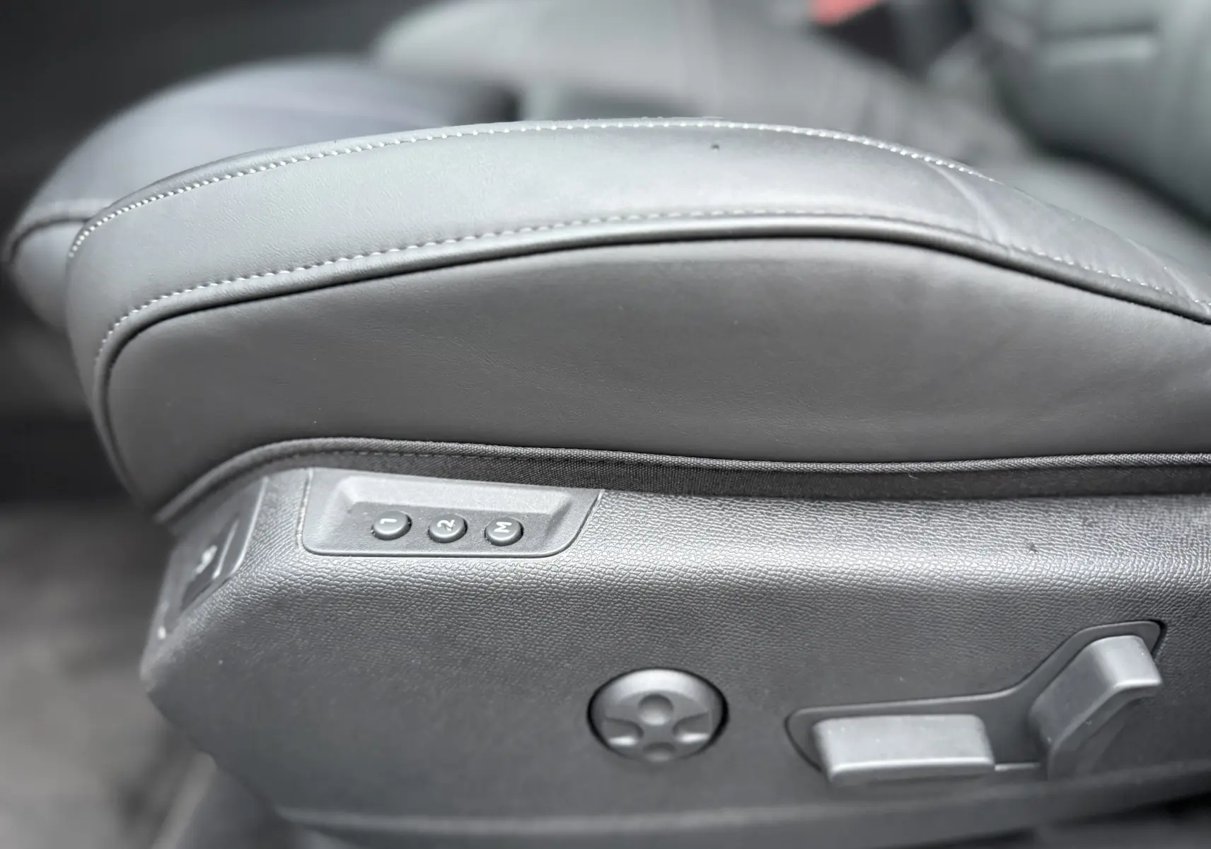 Gros plan sur les commandes électriques du siège avant gauche en cuir gris du DS7 BlueHDi 130 2025.