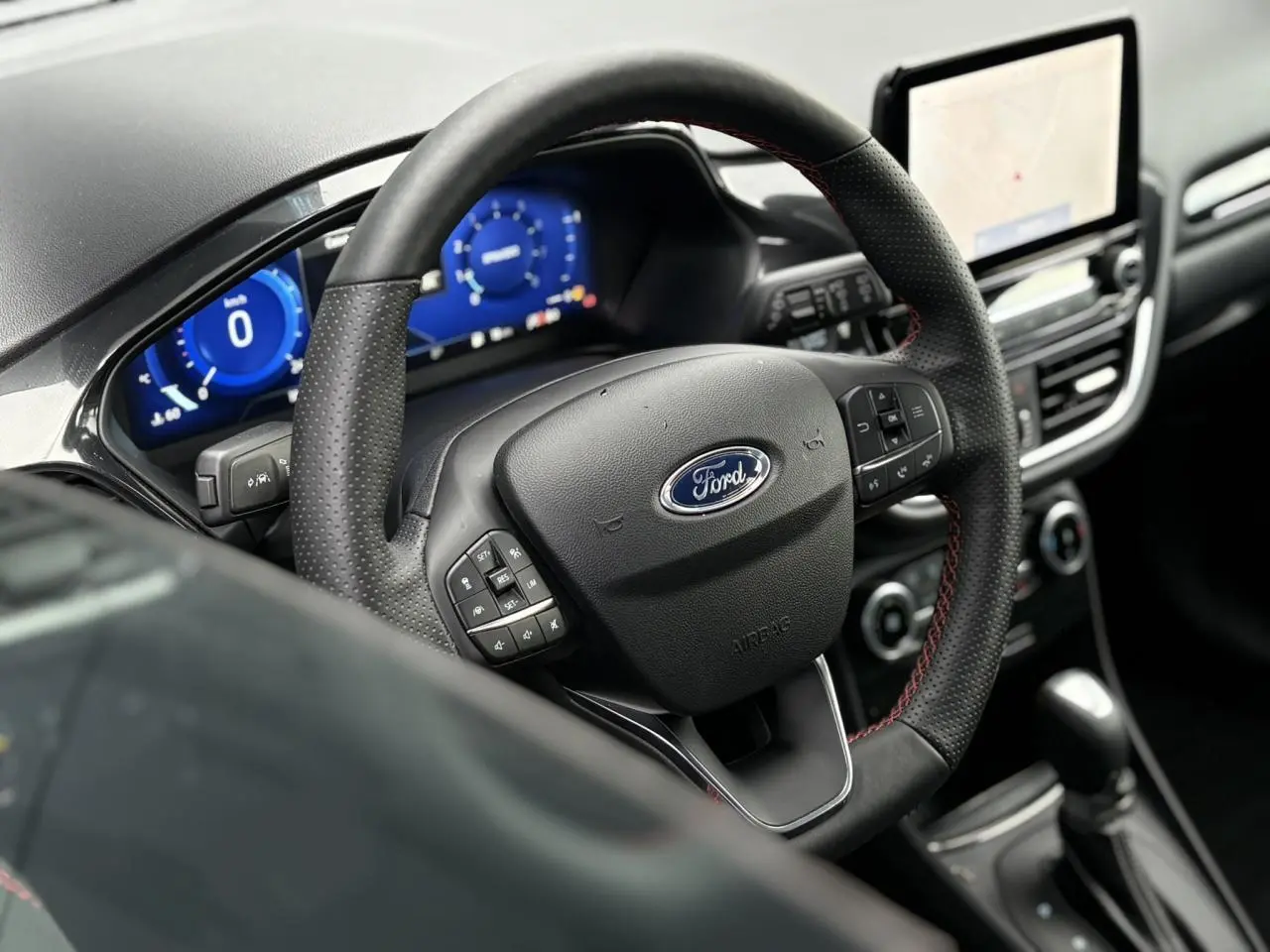 Vue rapprochée du volant ST-Line et du tableau de bord numérique bleu du Ford Puma gris Solar 2023.