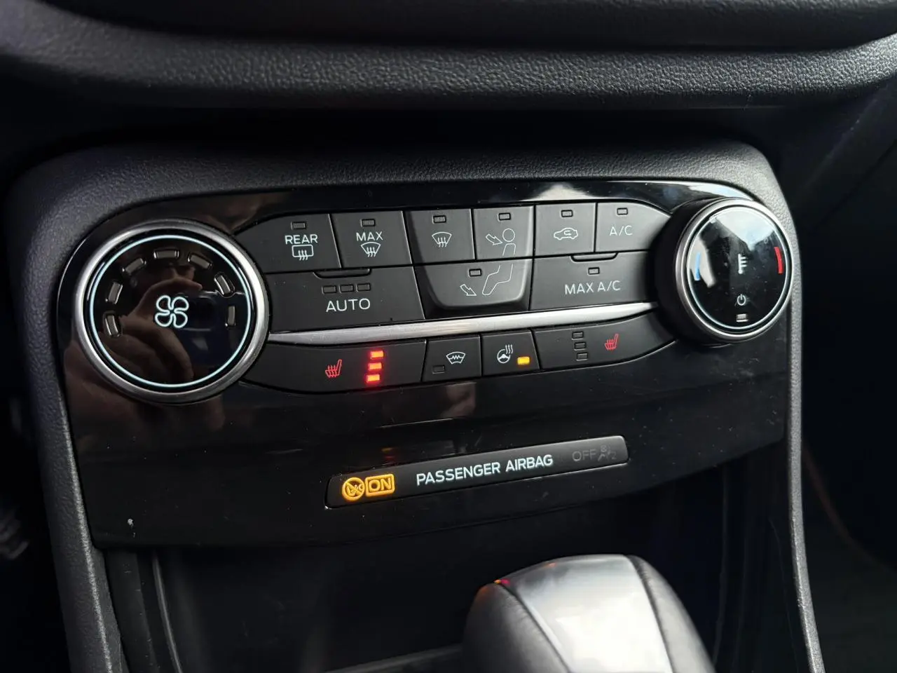 Gros plan sur la console centrale du Ford Puma 2023 gris Solar, montrant les commandes de climatisation et sièges chauffants.