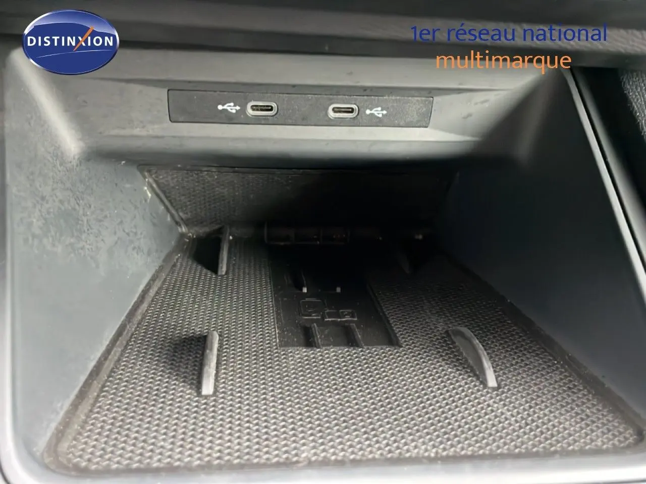 Gros plan sur la zone de rangement avant avec deux ports USB-C dans une SEAT LEON bleu Fjord 2025.