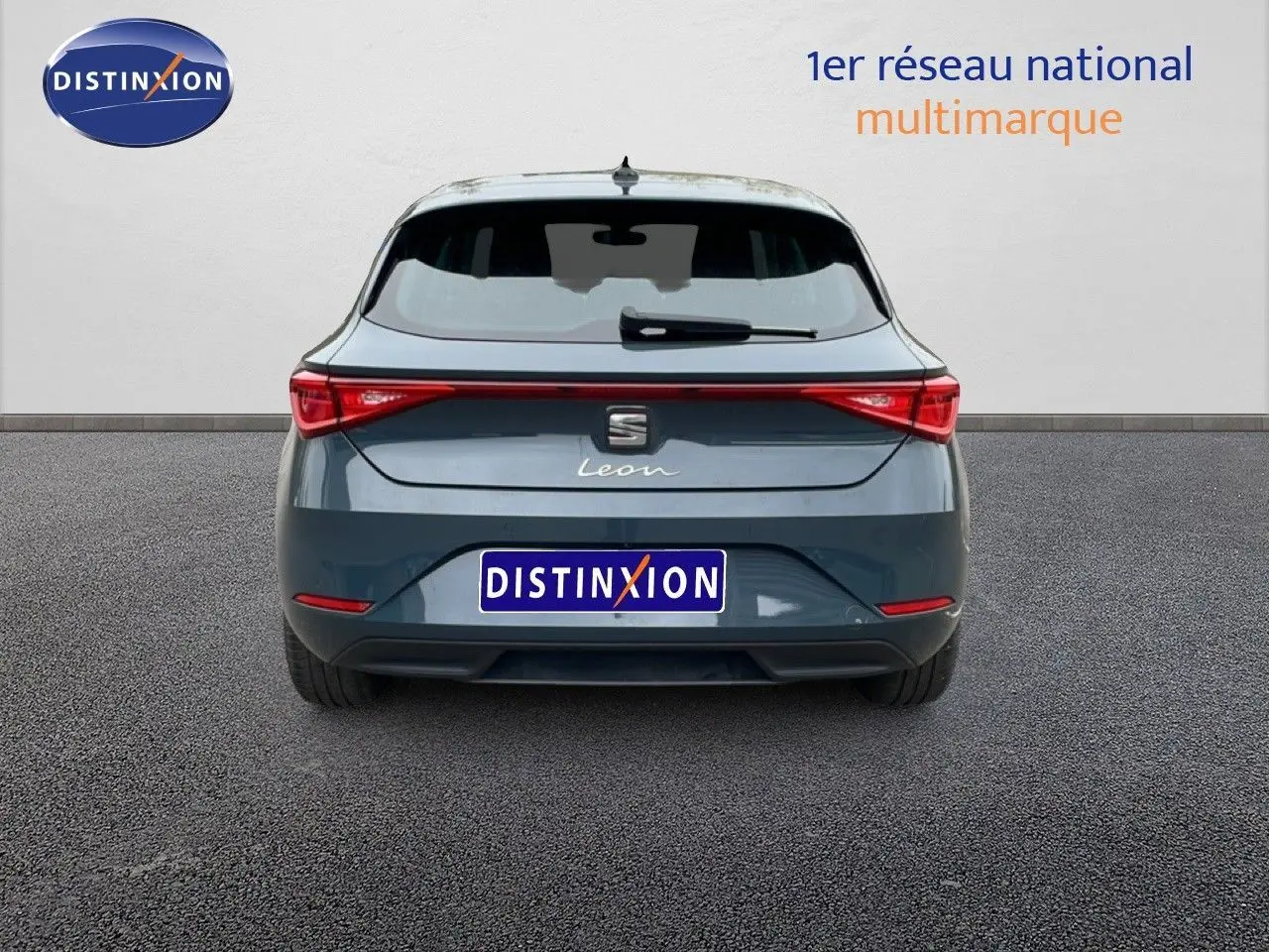 Vue arrière d'une SEAT Leon 2.0 TDI bleu fjord, mettant en valeur ses feux LED étirés et son design compact.