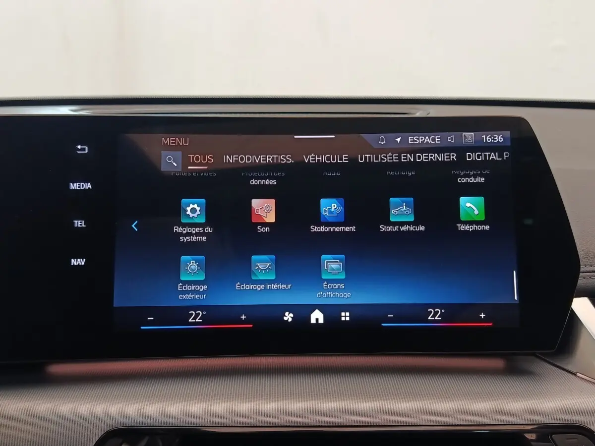 Écran tactile central du tableau de bord du BMW X1 xDrive25e M Sport 2024 affichant les réglages du système et du stationnement.