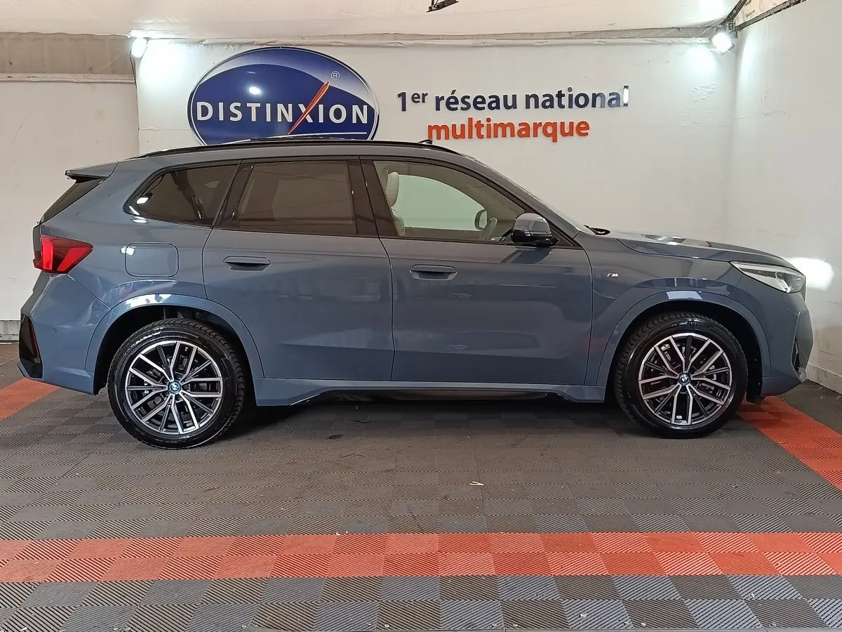 BMW X1 xDrive25e M Sport gris foncé vue de profil côté gauche, avec jantes alliage et vitres teintées.