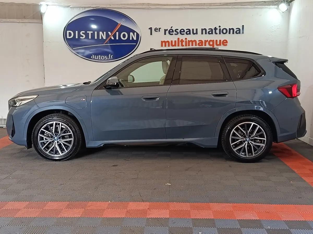 BMW X1 xDrive25e M Sport gris foncé vue de profil côté gauche, avec jantes alliage et toit noir contrasté.