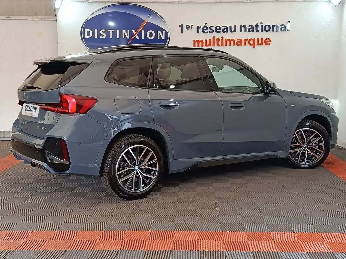 BMW X1 xDrive25e M Sport gris foncé vue de profil droit, avec jantes alliage et toit noir contrasté.