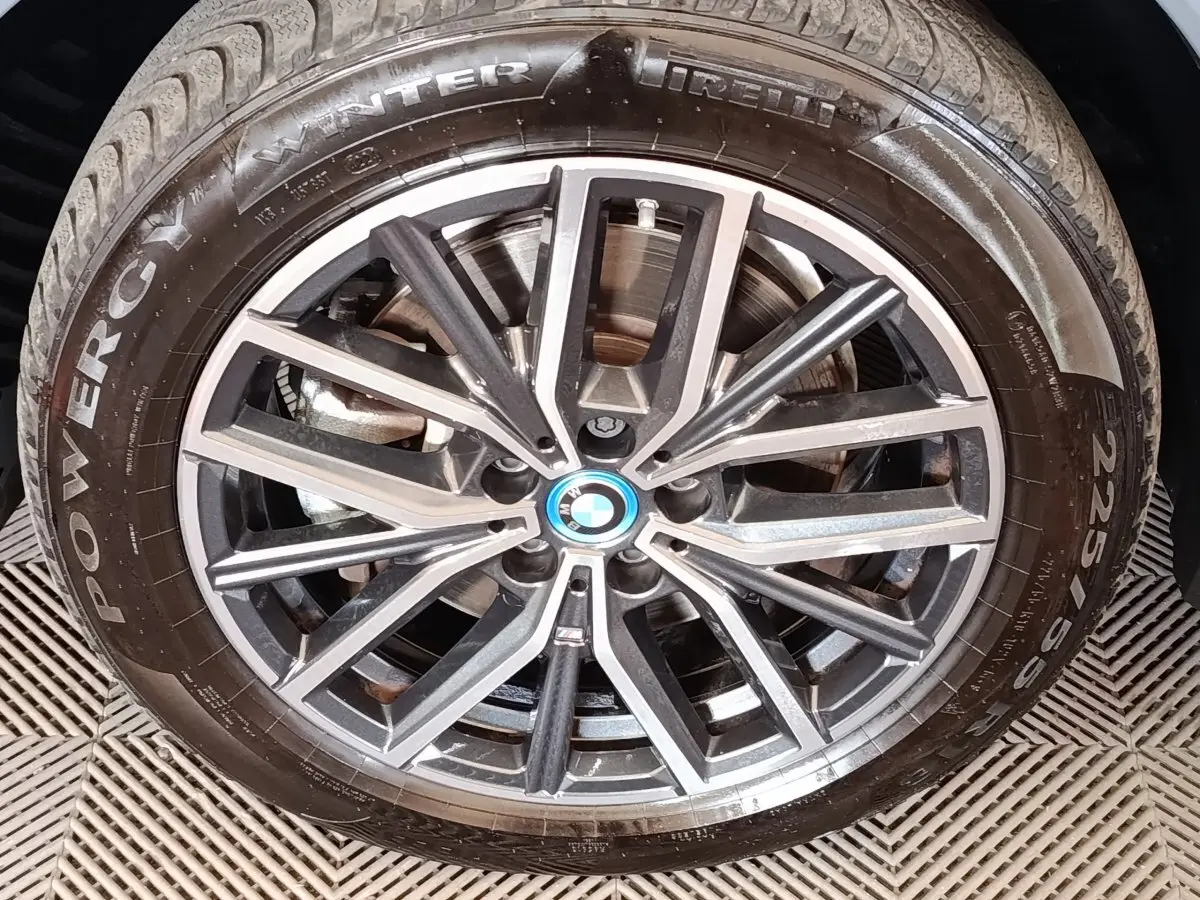 Gros plan sur la jante alliage bicolore et pneu hiver Pirelli du BMW X1 xDrive25e gris foncé.