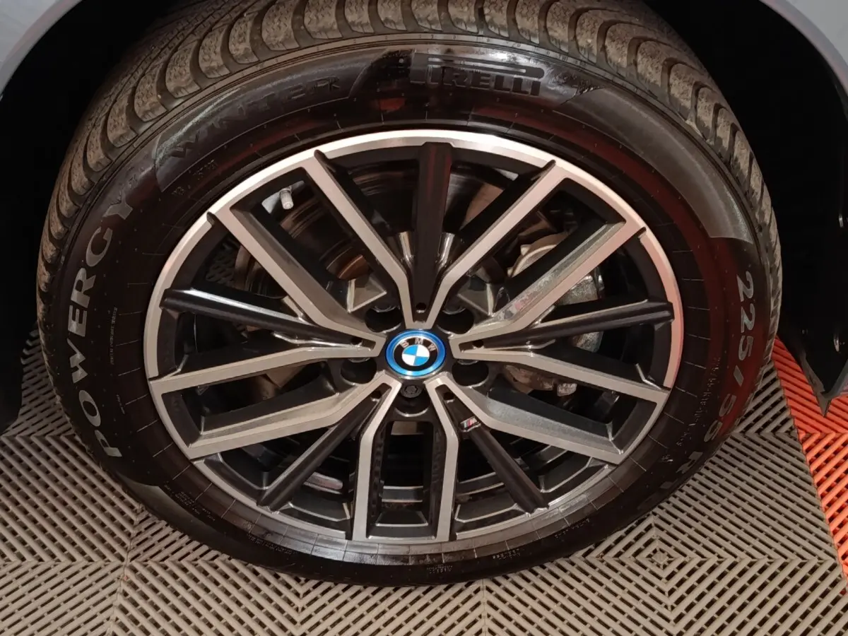 Gros plan sur la jante alliage noire et argentée d’un BMW X1 xDrive25e M Sport gris foncé, pneu Pirelli visible.