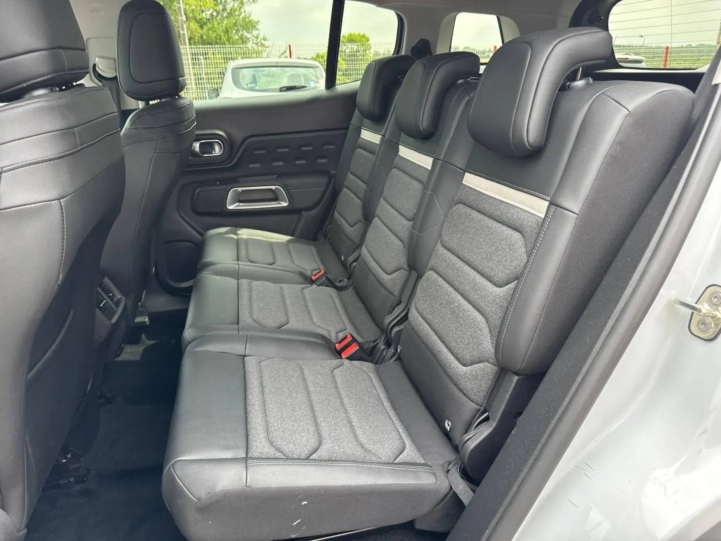 Vue latérale droite de la 2e rangée de sièges individuels noirs et gris du Citroën C5 Aircross blanc Okénite.
