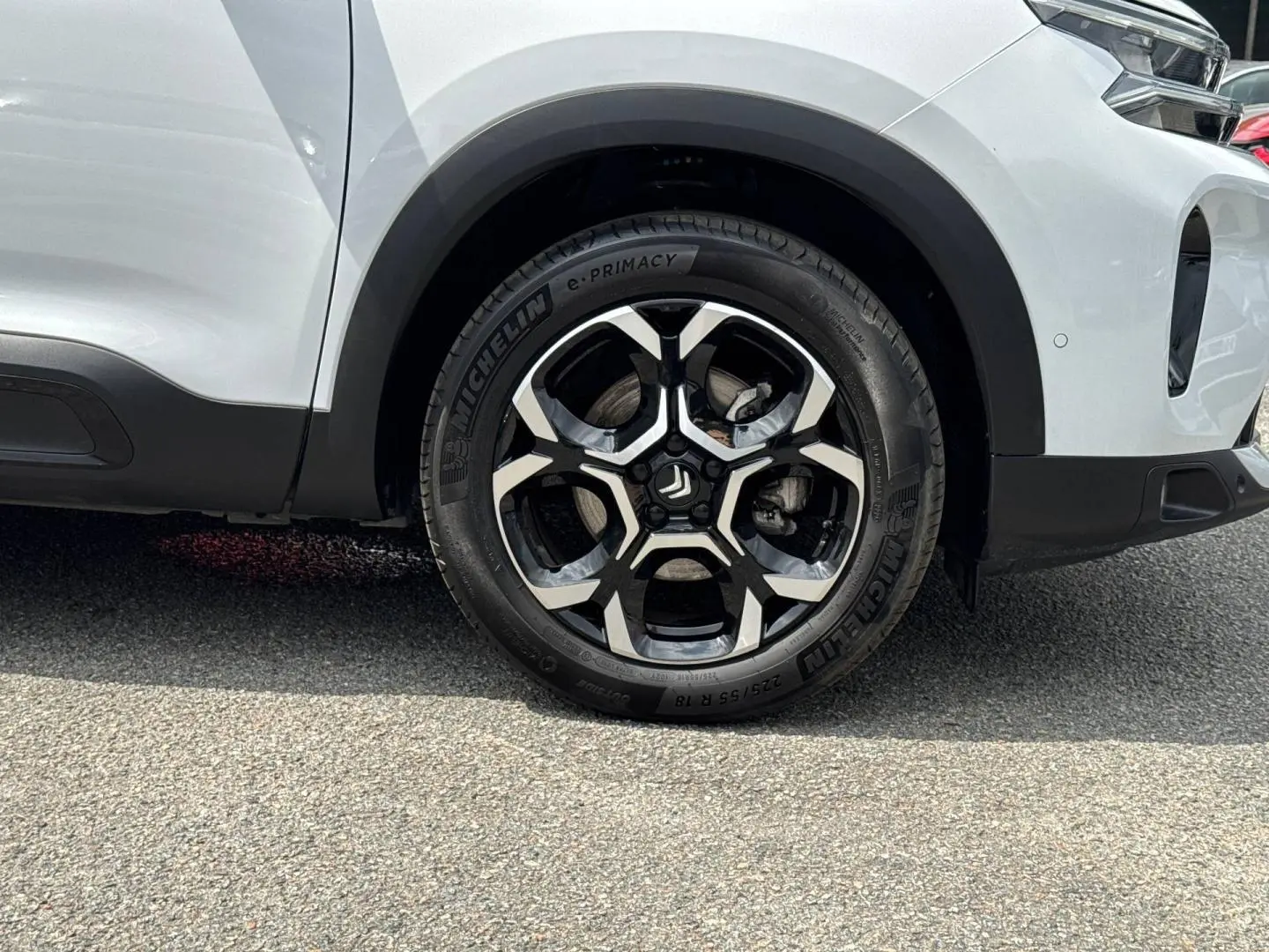 Gros plan sur la roue avant droite d'un Citroën C5 Aircross blanc Okénite avec jante alliage noire et argent.