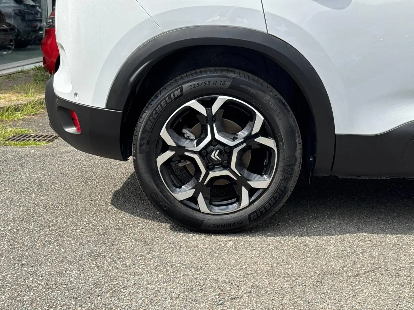 Gros plan sur la roue arrière droite d'un Citroën C5 Aircross blanc Okénite avec jante alu noire et argent.