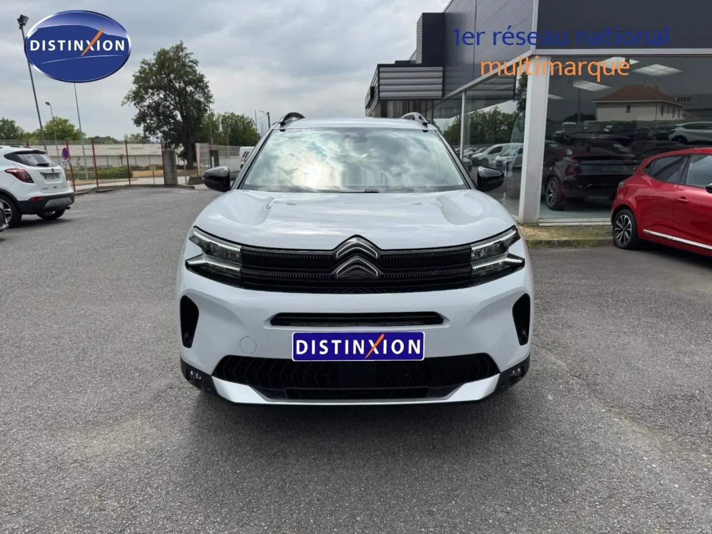 Vue avant d'un Citroën C5 Aircross blanc Okénite avec calandre noire et barres de toit visibles.