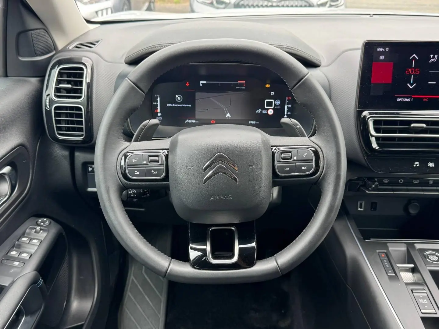 Vue intérieure centrée sur le volant cuir noir et le tableau de bord numérique du Citroën C5 Aircross 2025.