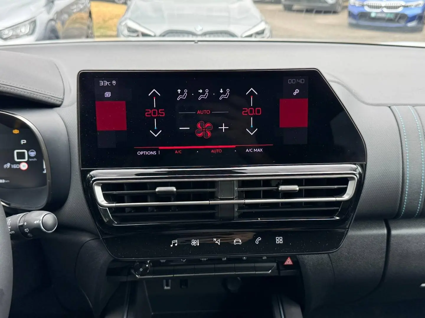 Vue intérieure du tableau de bord du Citroën C5 Aircross 2025, écran tactile avec commandes climatisation et finition noire avec surpiqûres bleues.