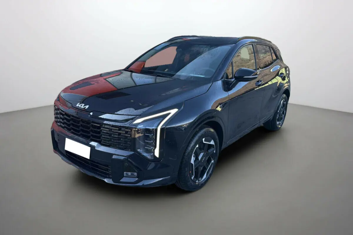 KIA SPORTAGE 1.6 T-GDI HEV noir étoilé en 3/4 avant droit avec phares Matrix LED allumés et jantes alu 19 pouces.