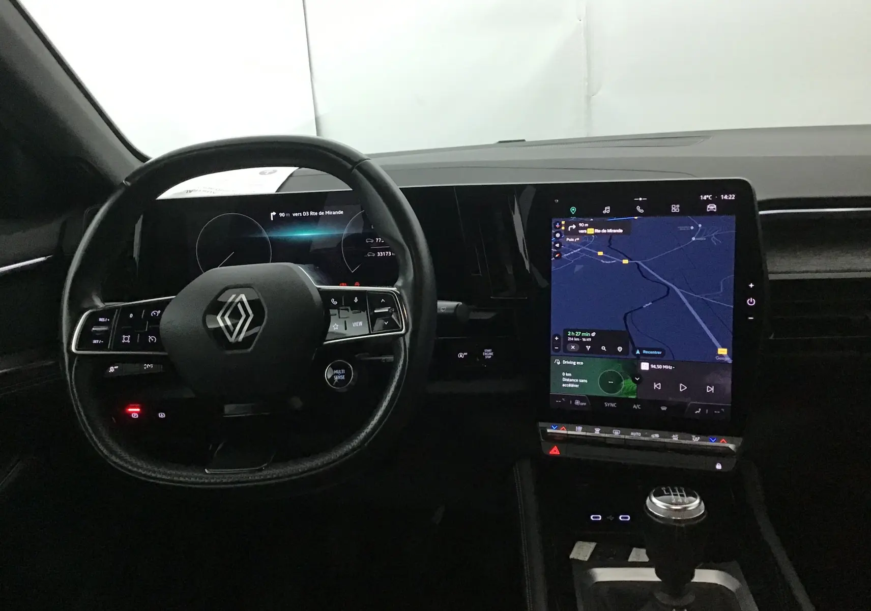 Intérieur du Renault Austral 2023, vue du poste de conduite avec tableau de bord numérique et écran tactile central allumé.