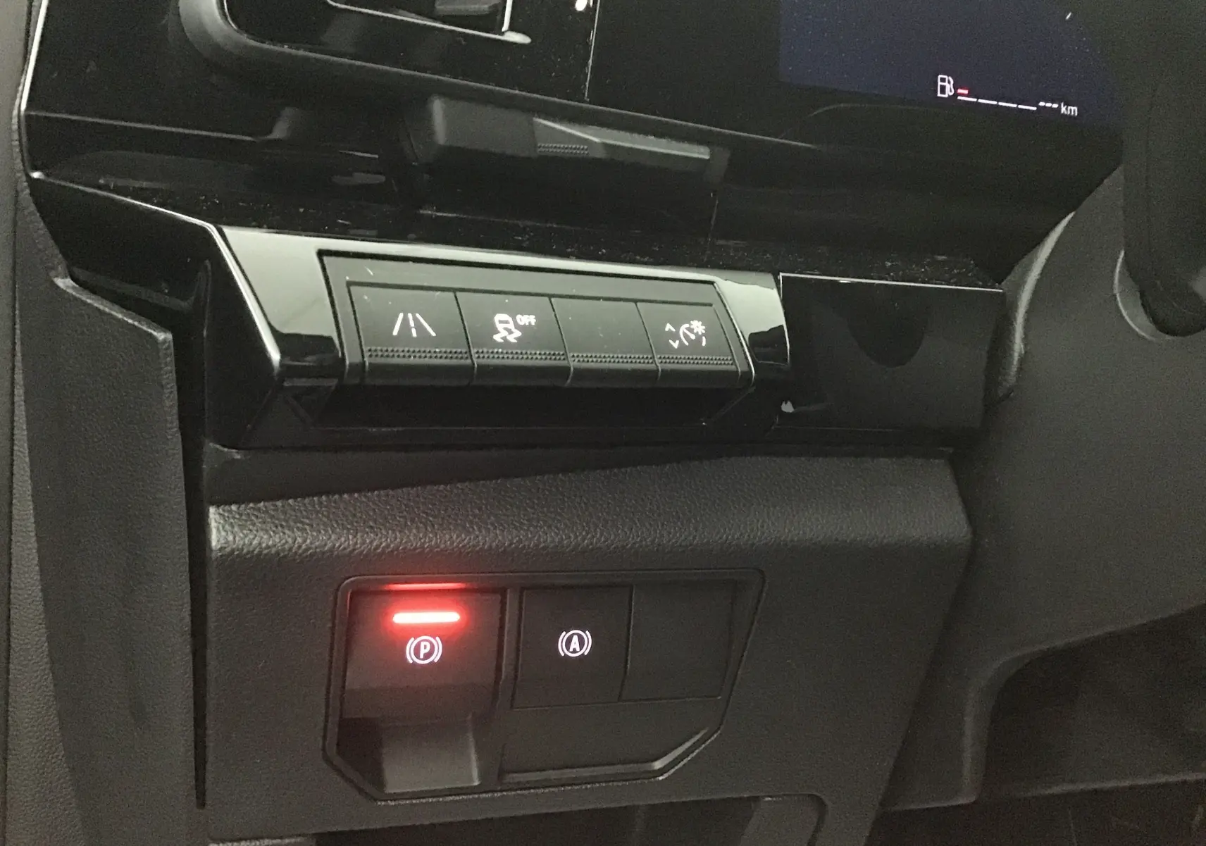 Détail des commandes du tableau de bord du Renault Austral 2023, avec bouton de frein à main électronique allumé.