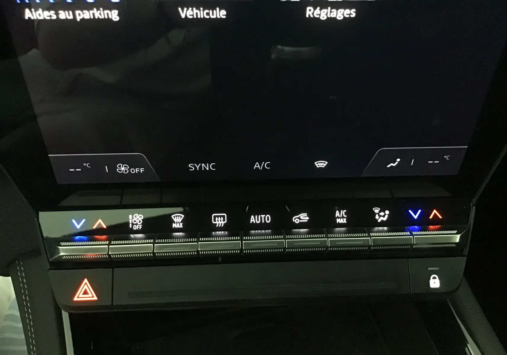 Vue rapprochée de la console centrale du Renault Austral bleu iron/noir, mettant en valeur les commandes tactiles de climatisation et l'écran numérique.