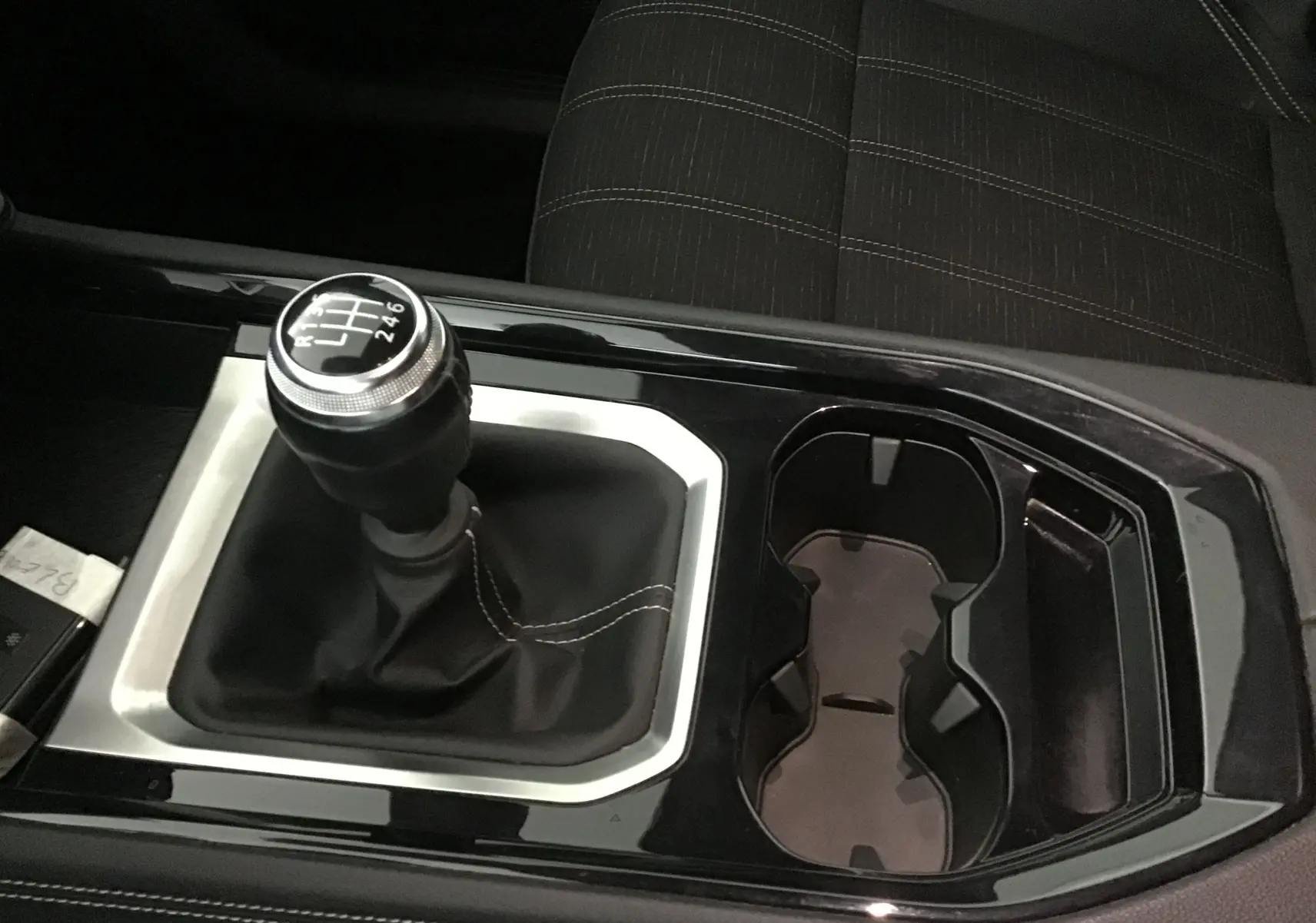 Le levier de vitesses manuel noir avec surpiqûres blanches dans la console centrale du Renault Austral 2023.