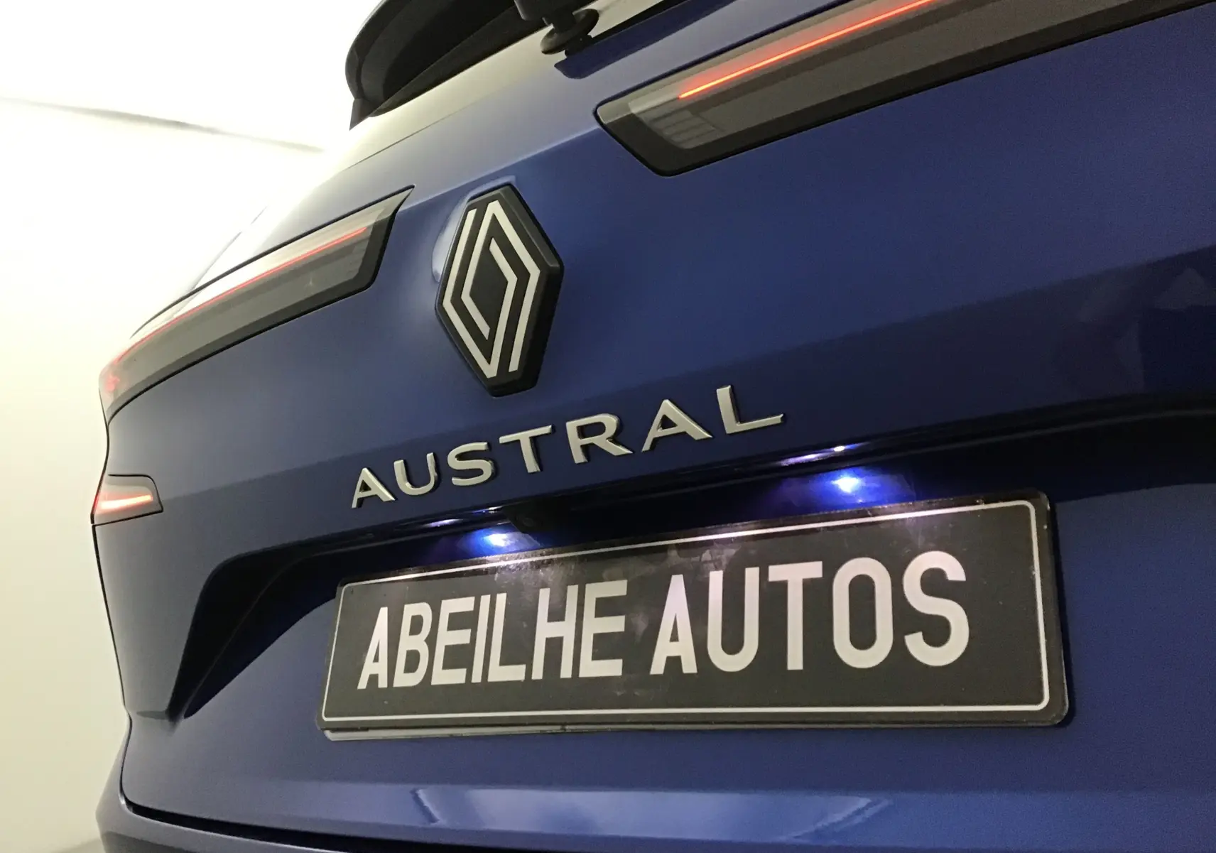 Vue rapprochée arrière du Renault Austral bleu iron avec logo et feux LED fins soulignant la silhouette moderne.
