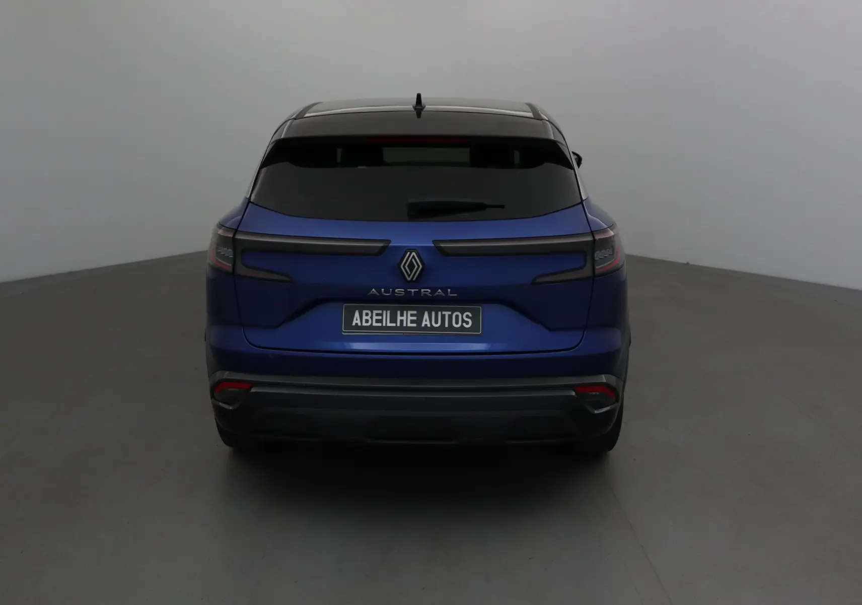 Vue arrière du Renault Austral 2023 bleu Iron avec toit noir et feux arrière horizontaux fins.
