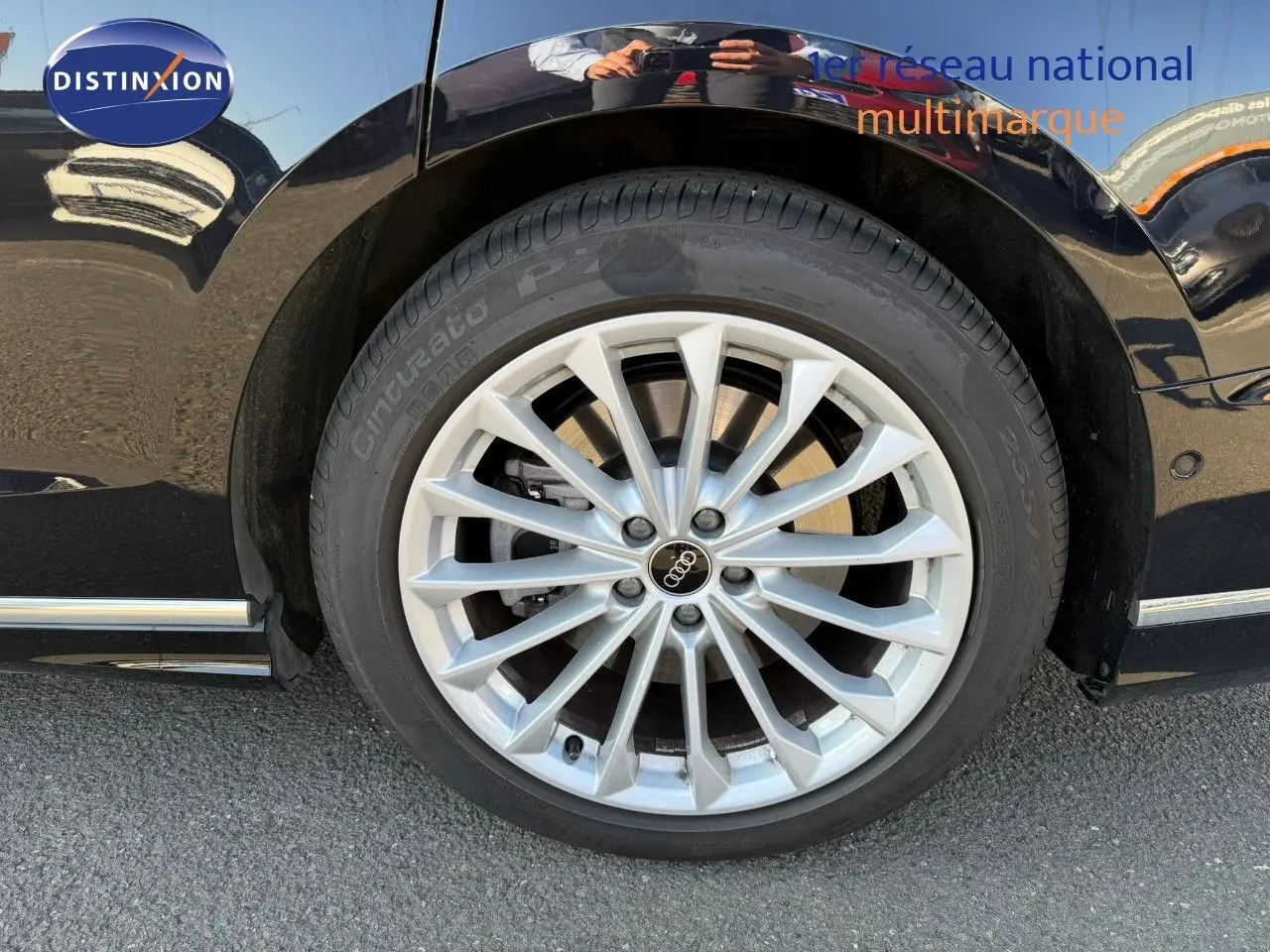 Gros plan sur la roue avant droite de l'Audi A8 noire Sebring Cristal, mettant en valeur la jante aluminium multibranches.