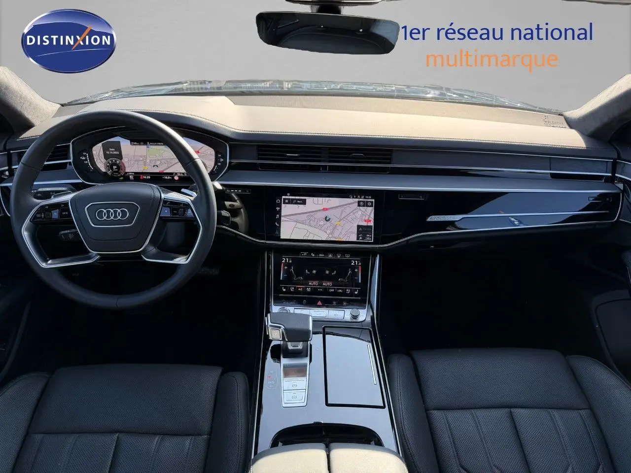 Vue intérieure avant de l'Audi A8 2024 noire Sebring Cristal, tableau de bord moderne avec écran tactile et volant multifonction.