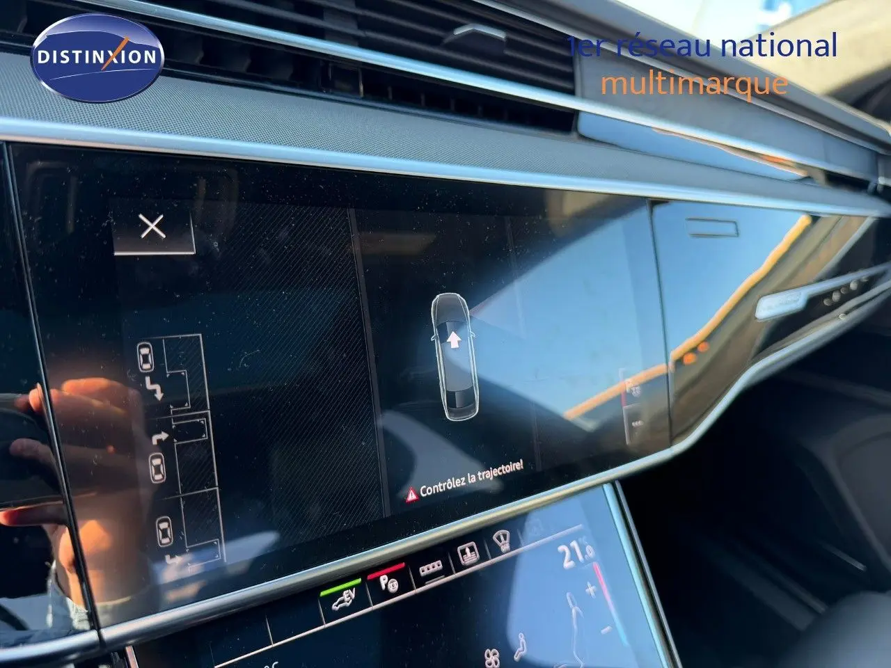 Vue rapprochée de l'écran tactile central de l'Audi A8 noire Sebring Cristal 2024, affichant l'aide au stationnement.