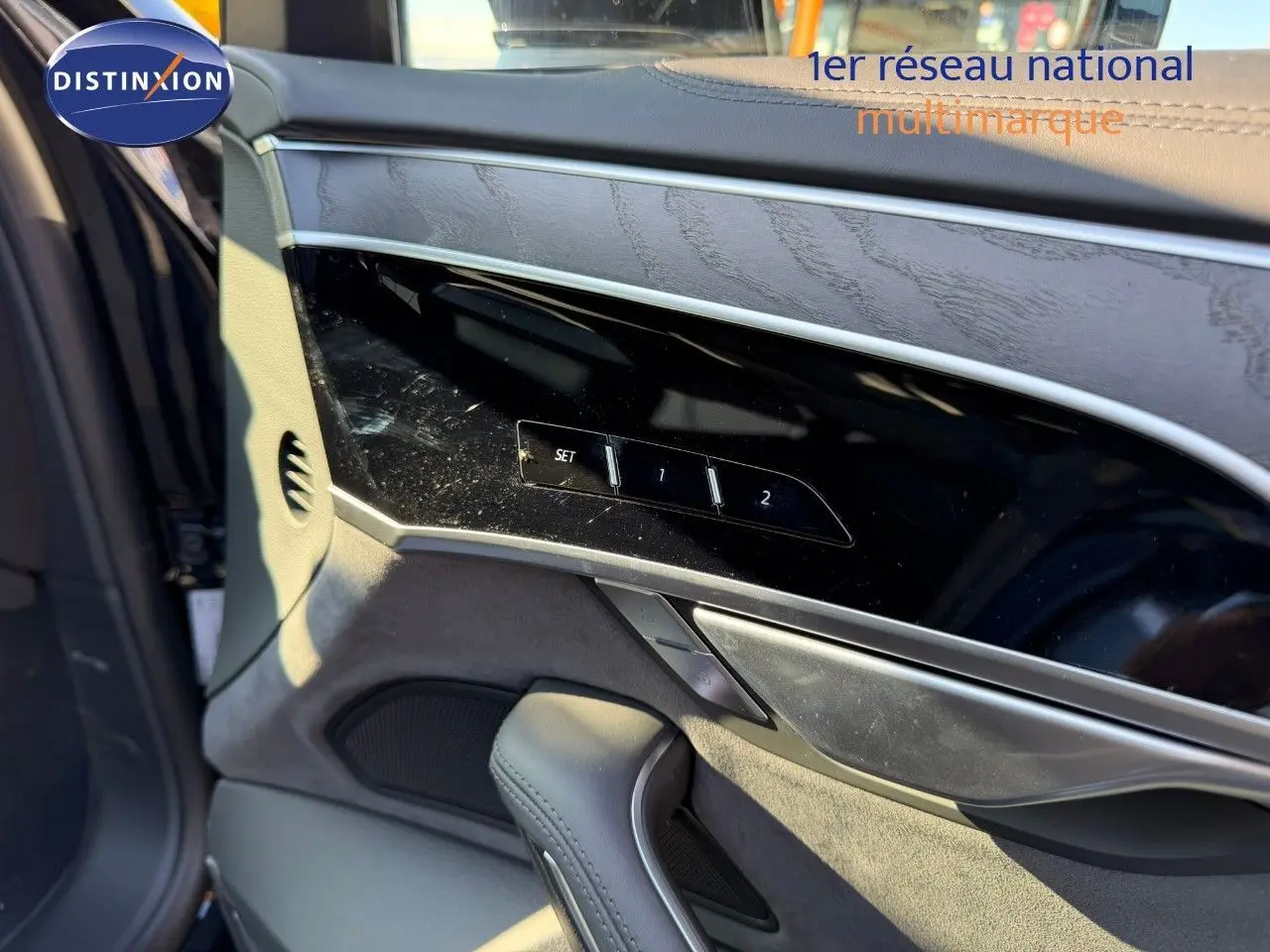 Détail de la porte côté gauche d'une Audi A8 2024 noire Sebring Cristal, avec commandes mémoire des sièges et garniture bois.