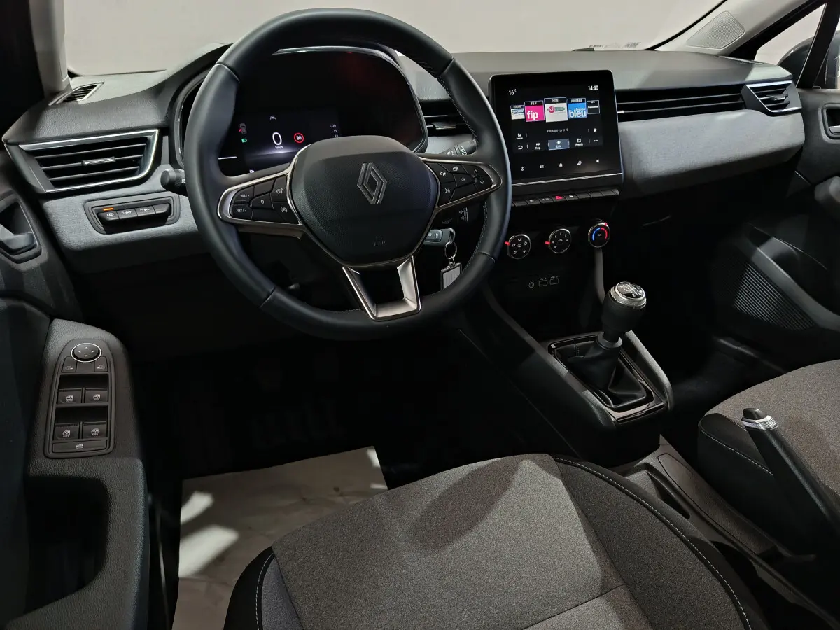 Intérieur de la Renault Clio Evolution Blue dCi 100 2025, vue du poste de conduite avec volant cuir et écran tactile central.