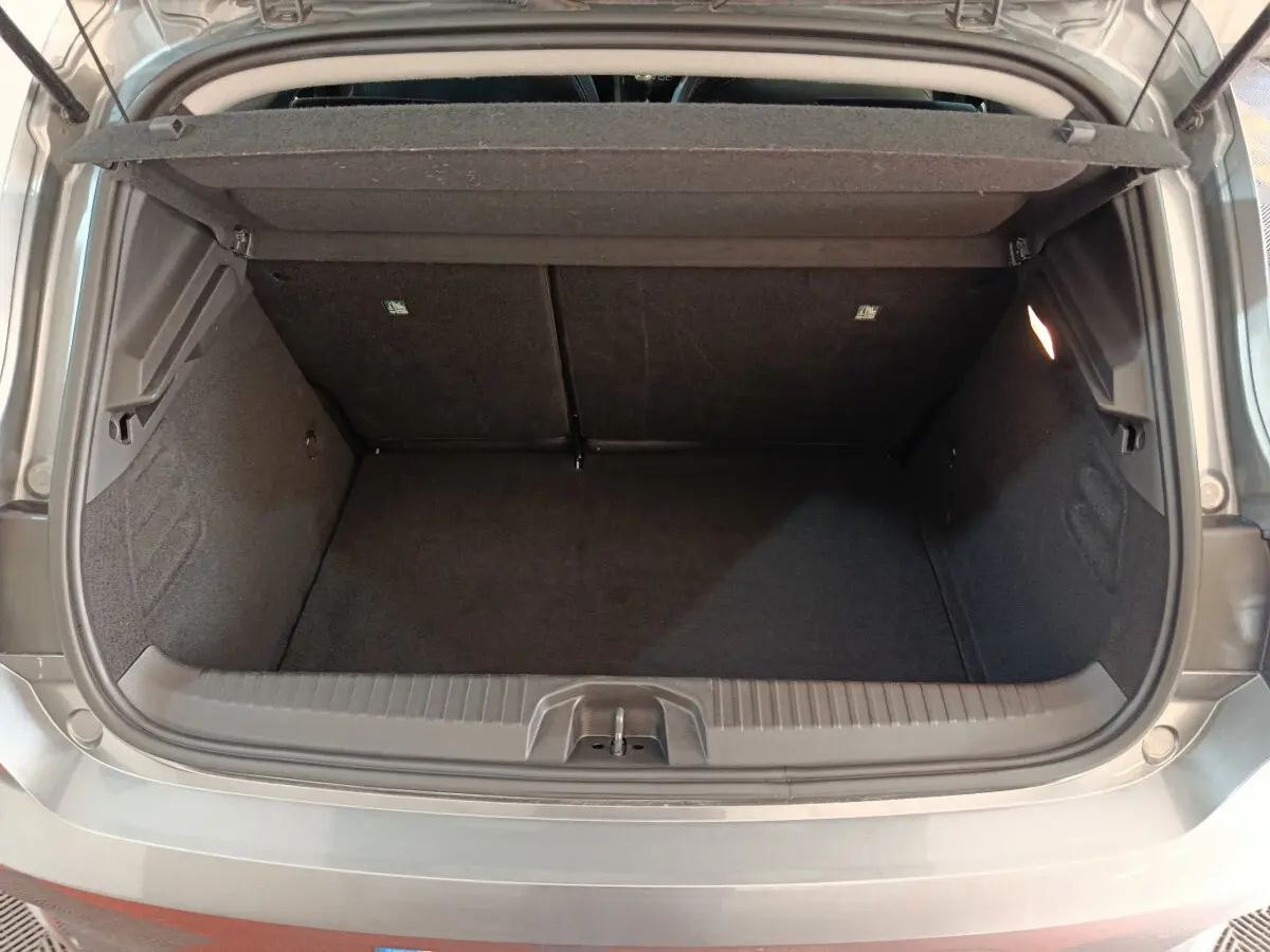 Coffre ouvert gris foncé de la Renault Clio Evolution Blue dCi 100 2025, montrant un espace de chargement vide et éclairé.